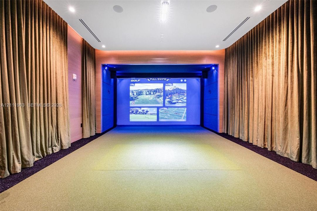 Dedicated simulator room featuring a high-definition projection screen, recessed ceiling lighting, integrated audio speakers, and wall-to-wall carpeting