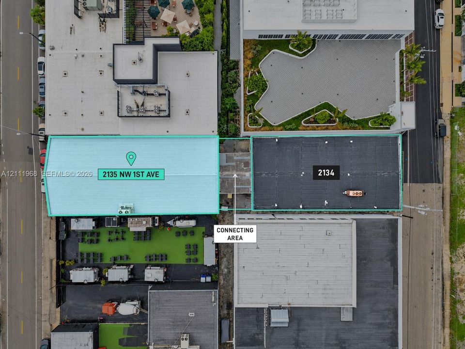 Aerial perspective of two distinct commercial structures featuring metal and flat roofing systems, including an exterior paved area and surface-level outdoor space