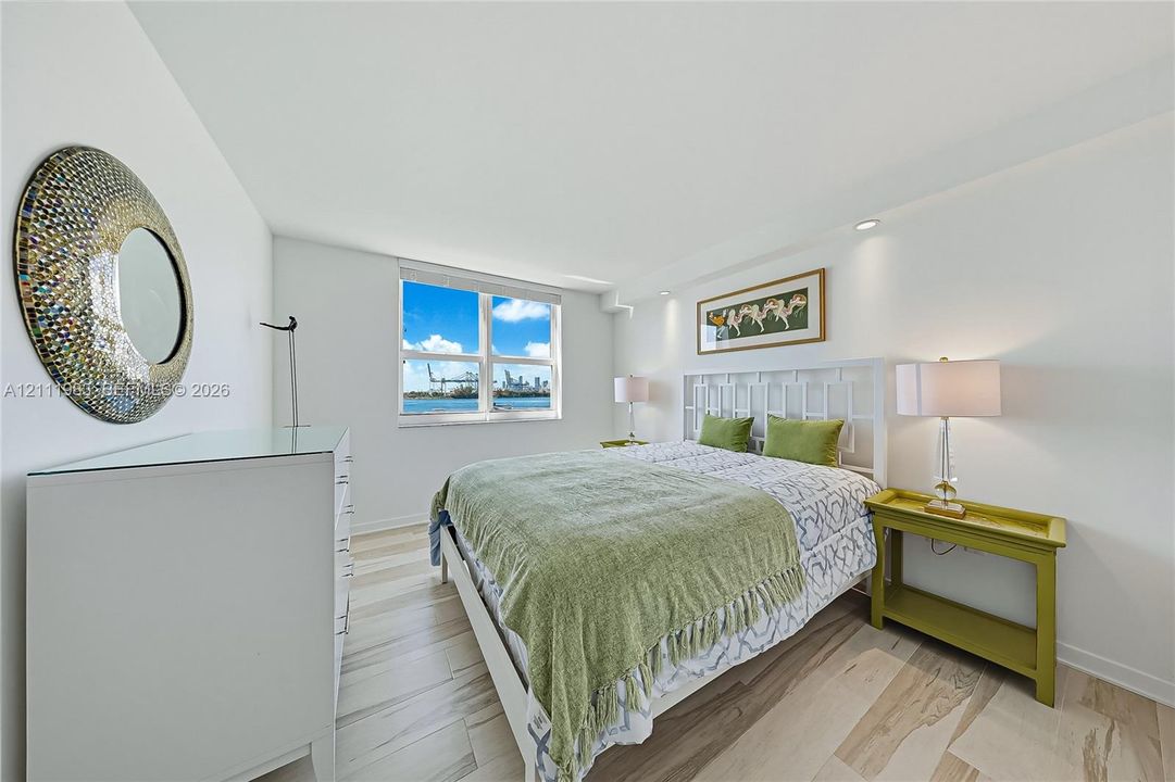 Interior space featuring light-toned tile flooring, recessed ceiling lighting, and window with water and skyline scenery