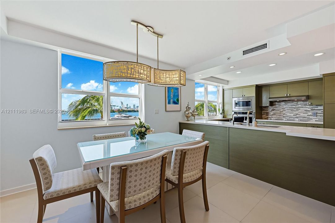 Kitchen featuring olive-toned cabinetry, quartz countertops, a multi-textured stone backsplash, built-in stainless steel appliances, and large-format tile flooring