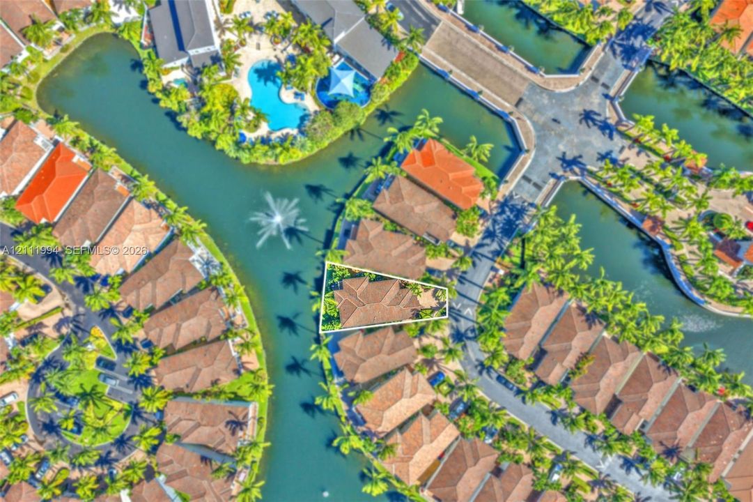 Aerial perspective of a property featuring a tiled roof and water frontage with direct canal access