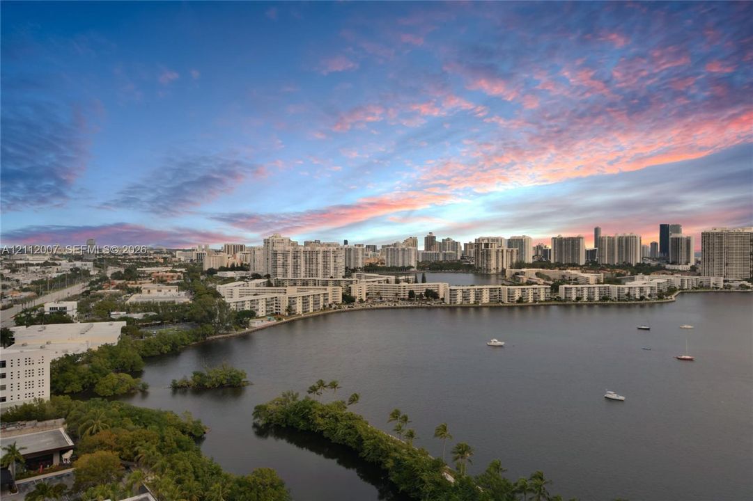 Elevated panoramic perspective of urban coastal surroundings featuring an expansive waterfront, mature mangrove-style vegetation, and a high-density skyline