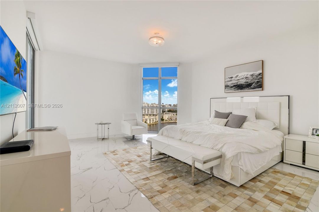 Spacious room featuring polished stone-finish flooring, floor-to-ceiling windows, and a flush-mount light fixture