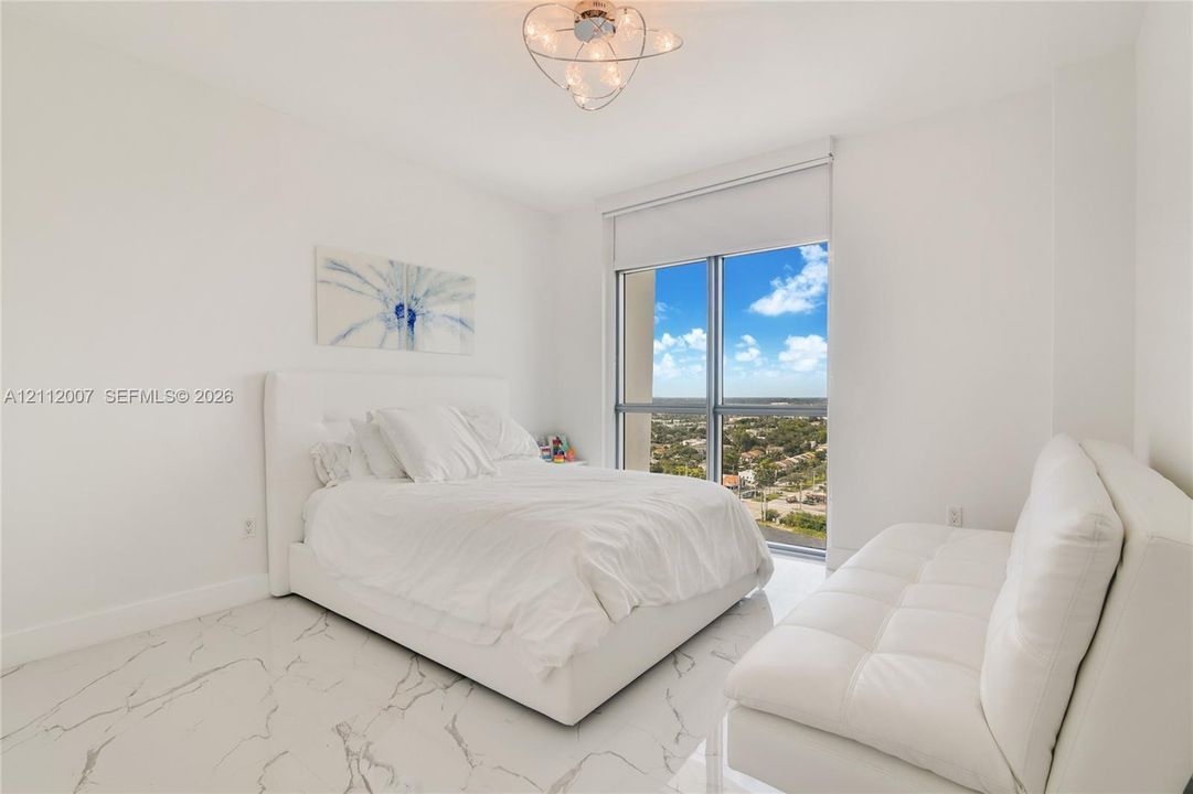 Polished stone-finish tile flooring, floor-to-ceiling windows with expansive exterior scenery, and modern orbital ceiling light fixture