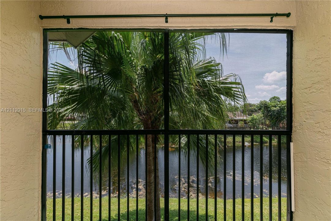 Screened-in enclosure featuring a black metal frame, textured wall finishes, and a curtain rod