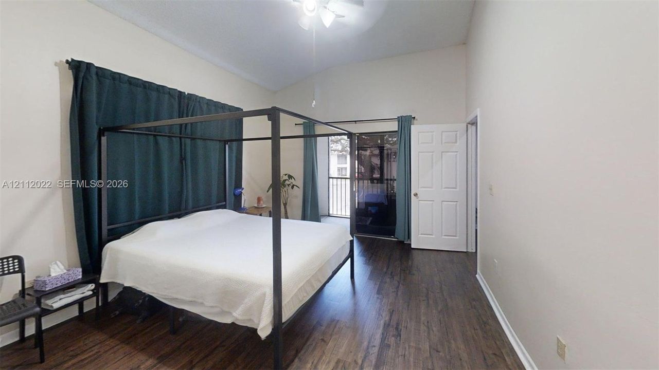 Vaulted ceilings, wood-finish flooring, and sliding glass doors providing outdoor access
