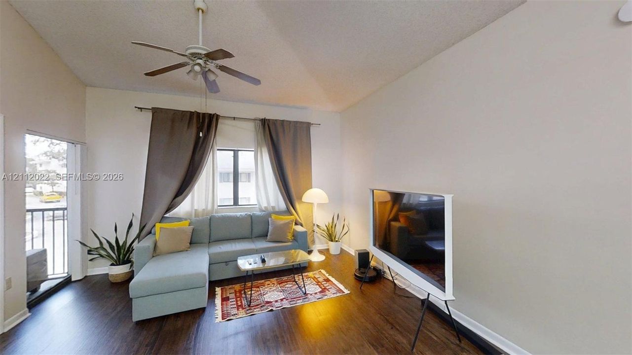 Vaulted ceilings, wood-finish flooring, and a ceiling fan with integrated lighting