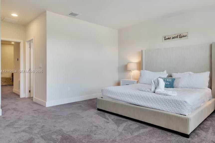 Neutral-toned carpeting, recessed ceiling lighting, and smooth wall finish