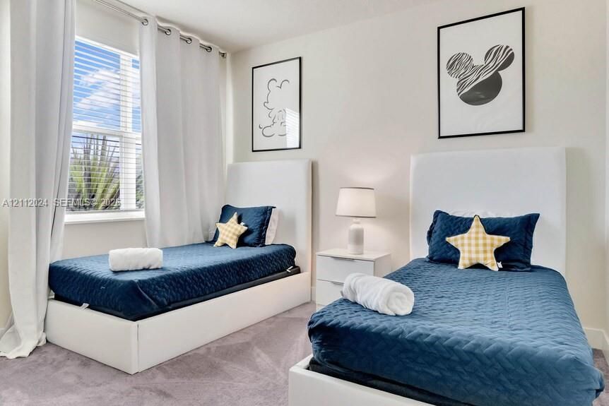 Neutral-toned wall finish, wall-to-wall carpeting, and a window with horizontal blinds