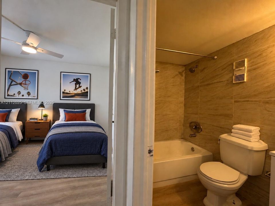 Bedroom featuring a white ceiling fan with integrated lighting and wood-finish flooring