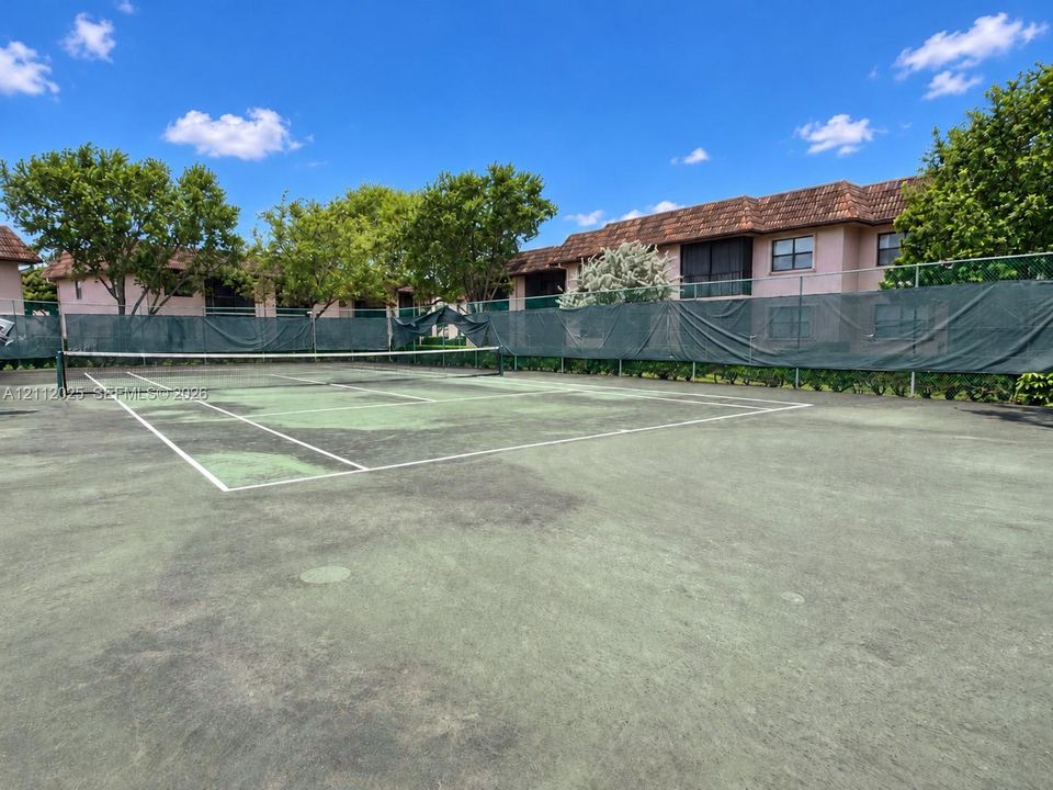 Tennis court with a paved surface and perimeter fencing