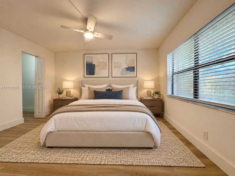 Neutral-toned interior featuring wood-finish flooring, a contemporary four-blade ceiling fan with integrated lighting, and horizontal window blinds