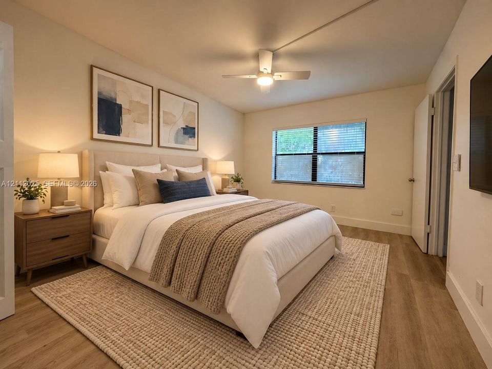 Neutral-toned interior space featuring wood-finish flooring, a ceiling fan with integrated lighting, and a single-pane window