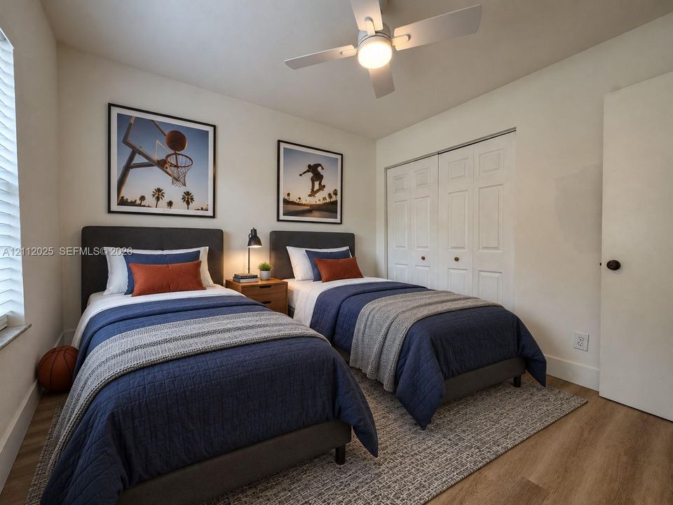 Neutral-toned room featuring wood-finish flooring, a white ceiling fan with integrated lighting, and a double-door closet with paneled detailing