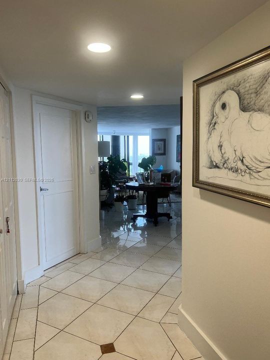Hallway featuring large-format diagonal tile flooring with decorative stone accents and recessed ceiling lighting