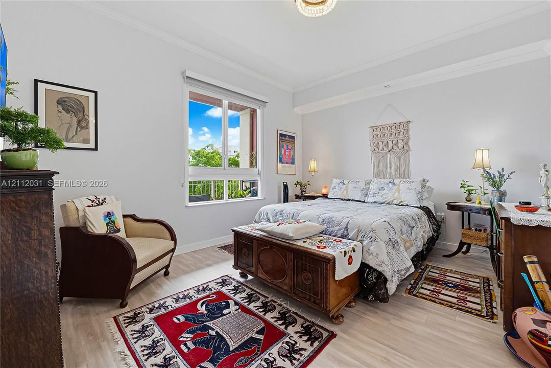 Light-filled interior featuring wood-finish flooring, crown molding, and a large window