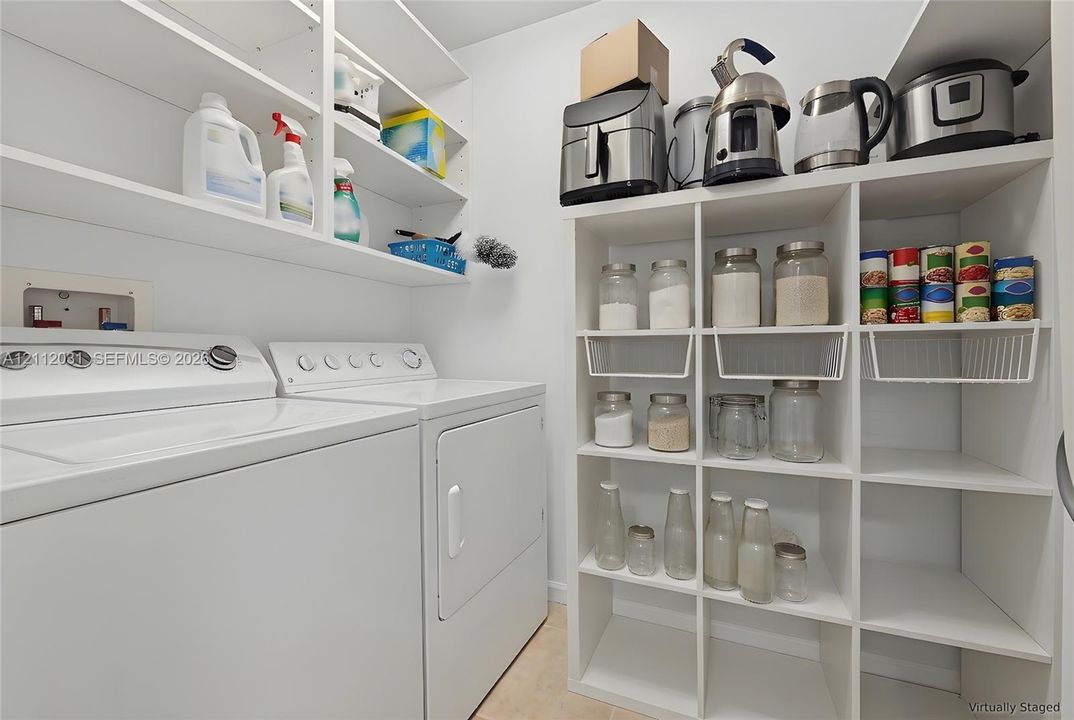 Utility room featuring floor-to-ceiling white built-in shelving, modular cube storage units, and laundry appliance hookups
