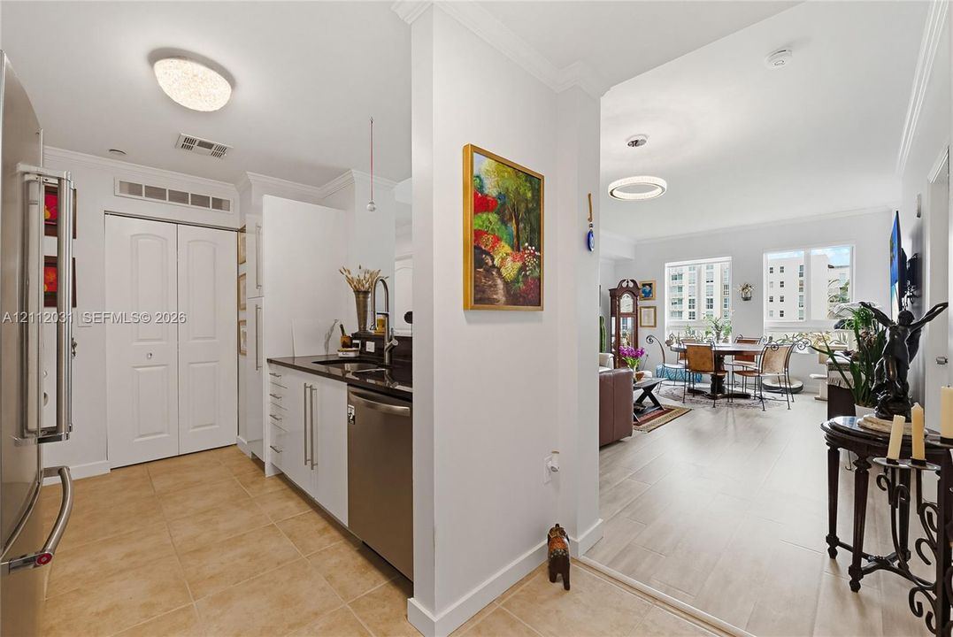 Kitchen featuring flat-panel cabinetry, dark solid-surface countertops, stainless steel dishwasher, tile flooring, and recessed lighting