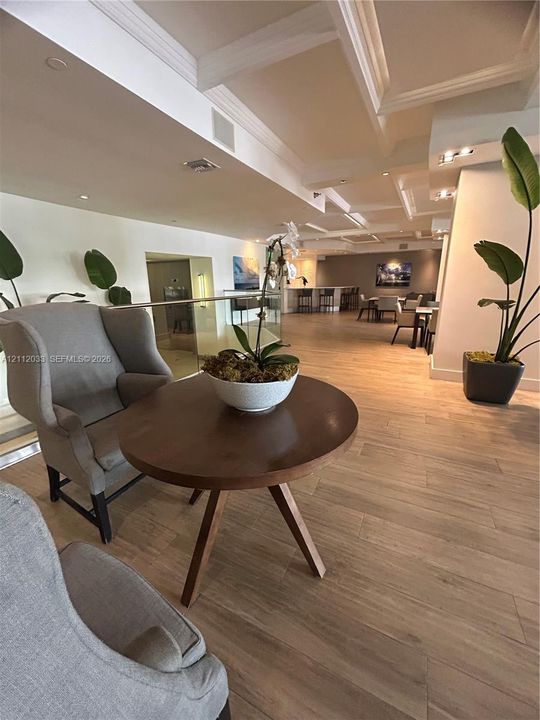 Wood-finish flooring, coffered ceiling with recessed lighting, and glass panel railing