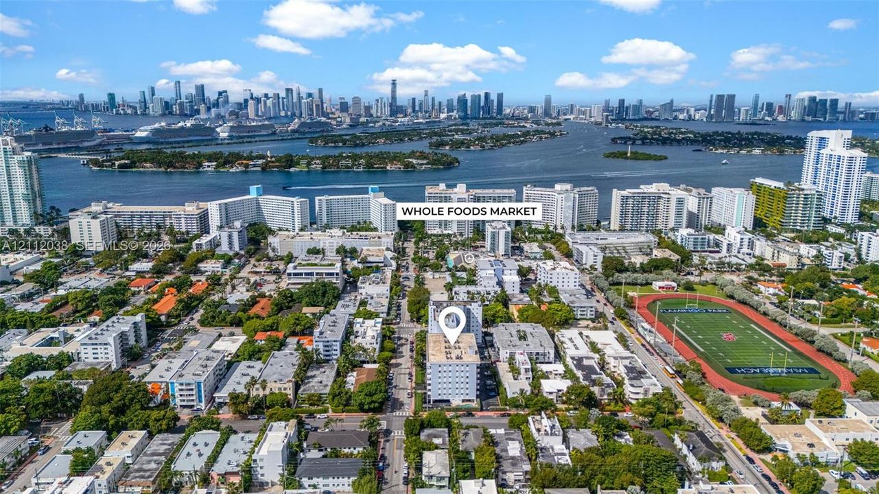 Aerial perspective featuring urban proximity to the coastline, waterfront buildings, and an athletic field