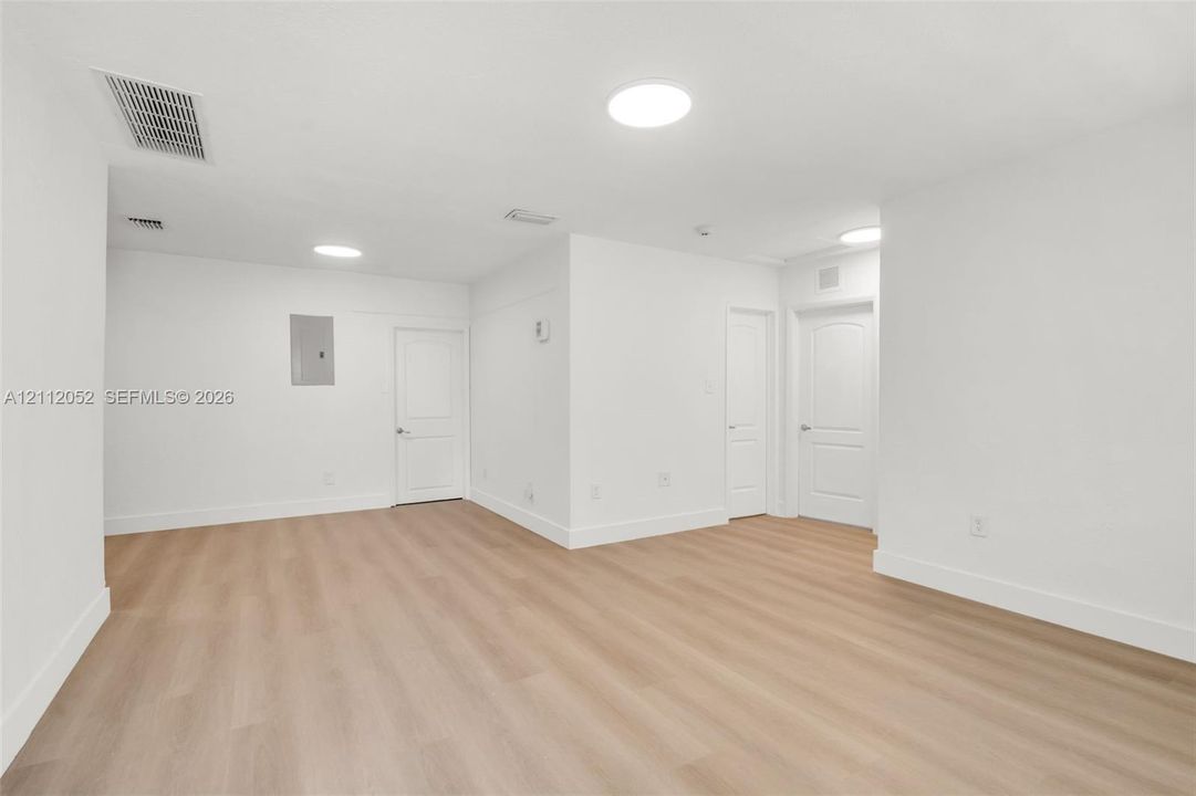 Interior space featuring wood-finish flooring, recessed lighting, and three panel doors