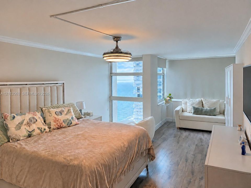 Floor-to-ceiling windows with water orientation, wood-finish flooring, and crown molding