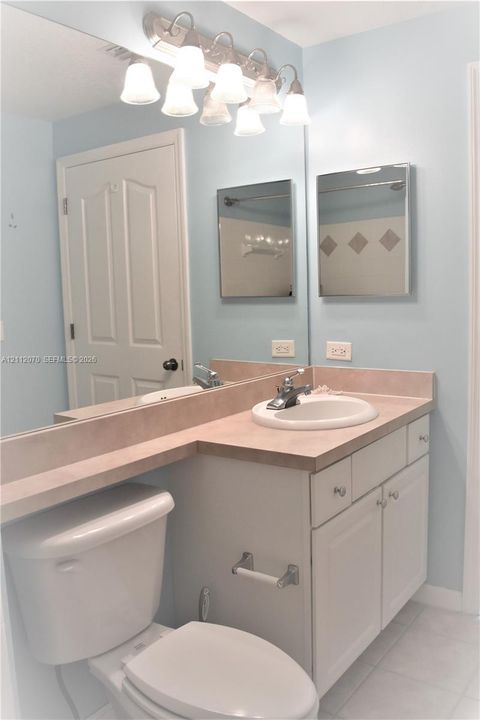 Vanity featuring a solid surface countertop, white shaker-style cabinetry, recessed-mount mirrored medicine cabinet, wall-to-wall mirror, and six-light fixture
