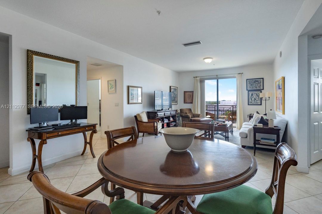 Open-concept main living area featuring diagonal tile flooring, sliding glass balcony doors, and recessed ceiling lighting