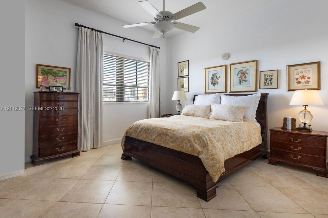 Neutral-toned tile flooring, large multi-pane window, and a central ceiling fan with integrated lighting