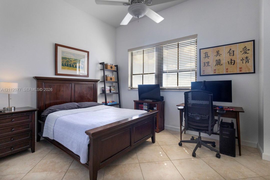 High-ceiling room featuring large-format tile flooring, a multi-blade ceiling fan with integrated light fixture, and horizontal window blinds