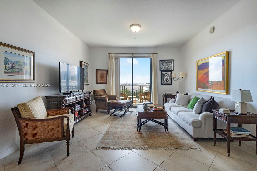 Neutral ceramic tile flooring, sliding glass doors, and a private balcony
