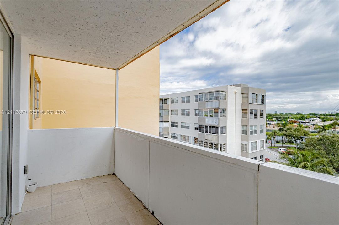 Covered balcony featuring concrete flooring and a waist-high perimeter wall