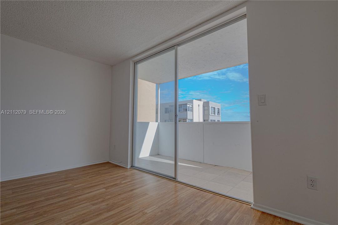 Wood-finish flooring, sliding glass door, and covered balcony with tile surfacing