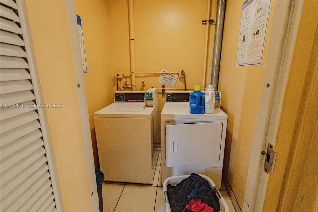 Dedicated laundry area featuring a top-load washer, front-load dryer, and tile flooring