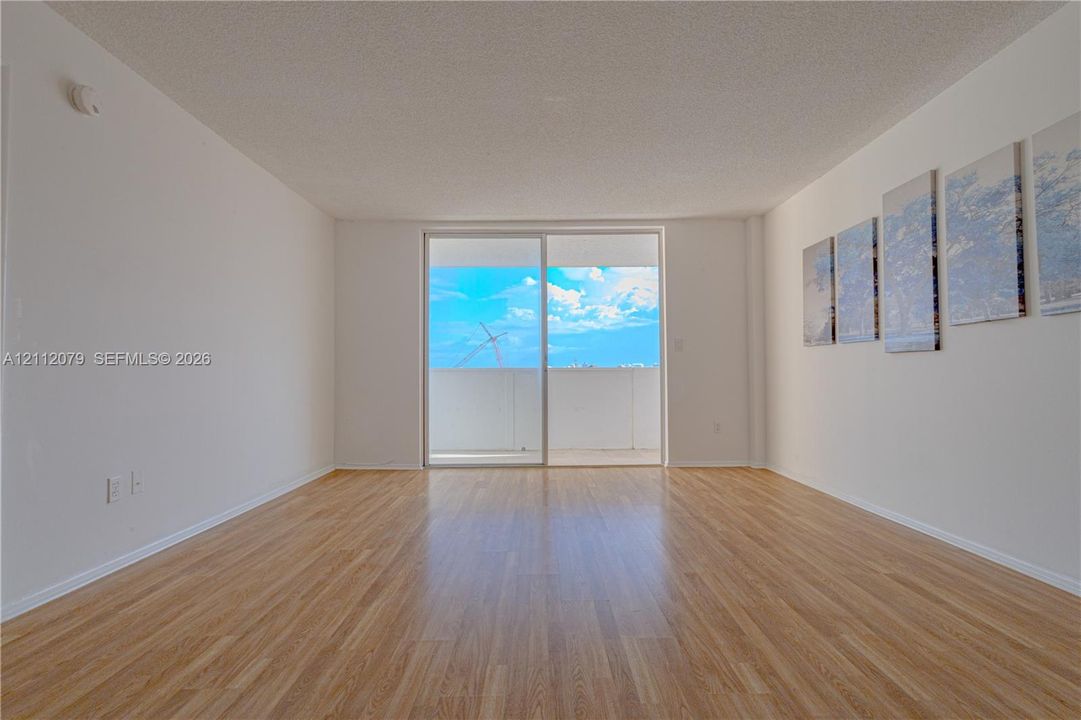 Interior space featuring wood-finish flooring, smooth-texture ceilings, and a sliding glass door providing external access