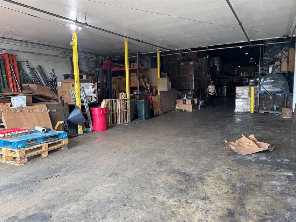 Open-concept warehouse space featuring a high-clearance ceiling, concrete flooring, and structural steel support columns