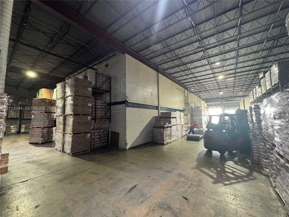 Industrial warehouse featuring high-clearance open-span ceilings, concrete flooring, and metal structural support beams