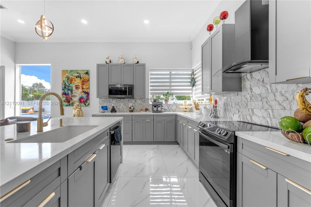 Kitchen featuring gray Shaker-style cabinetry, white solid-surface countertops, stone-tile backsplash, stainless steel appliances, and large-format porcelain tile flooring