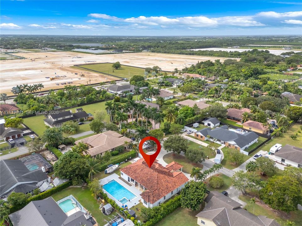 Aerial perspective featuring a tile roof, an in-ground swimming pool, and mature perimeter landscaping