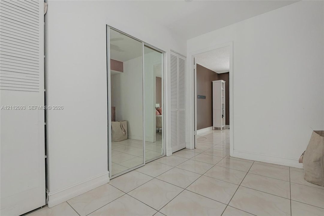 Tiled flooring, floor-to-ceiling mirrored sliding closet doors, and bi-fold closet doors