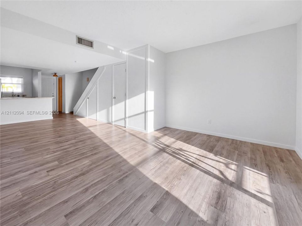 Interior featuring neutral wall paint, wood-finish flooring, and built-in closet storage