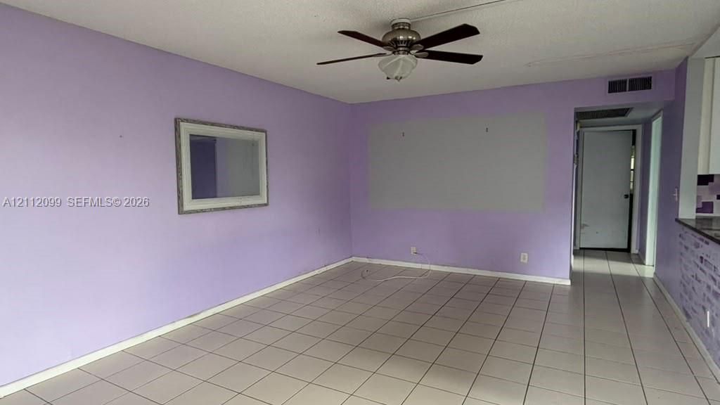 Ceramic tile flooring, ceiling fan with integrated lighting, and wall-mounted interior mirror
