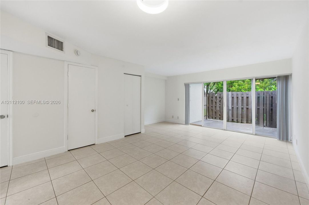Neutral-toned ceramic tile flooring, sliding glass doors, and solid-core interior doors