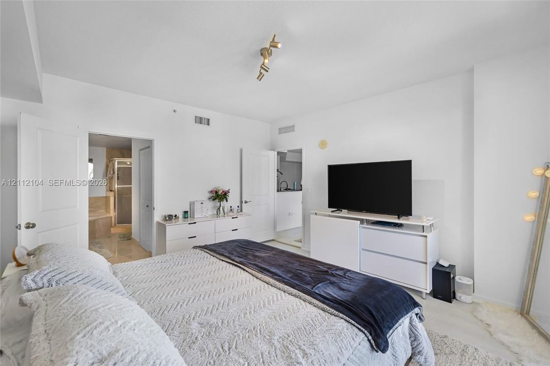 Room featuring neutral wall finishes, multi-directional track lighting, and shaker-style interior doors
