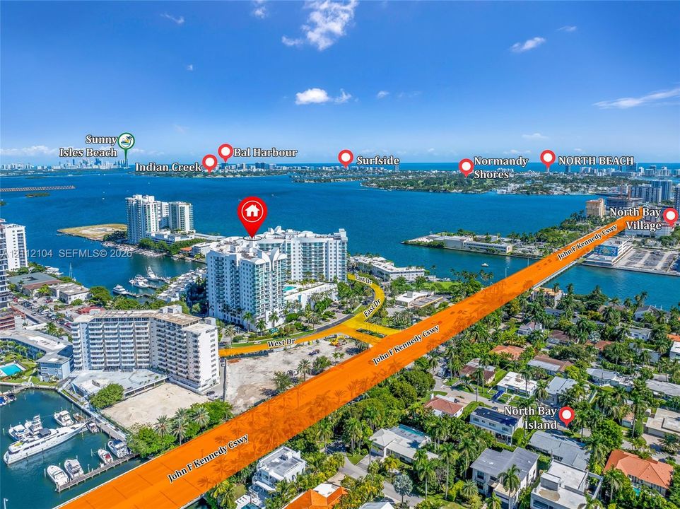 Aerial perspective featuring a multi-story high-rise waterfront building situated on the bay with private marina boat slips