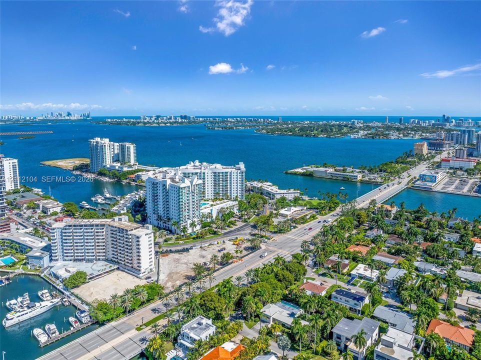 Aerial perspective showcasing expansive water frontage, deep-water access, established palm tree canopy, and proximity to municipal infrastructure