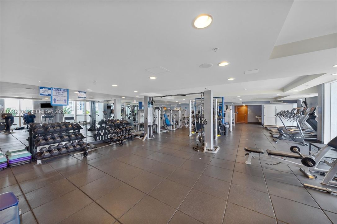 Fitness facility featuring tile flooring, recessed lighting, and expansive floor-to-ceiling windows