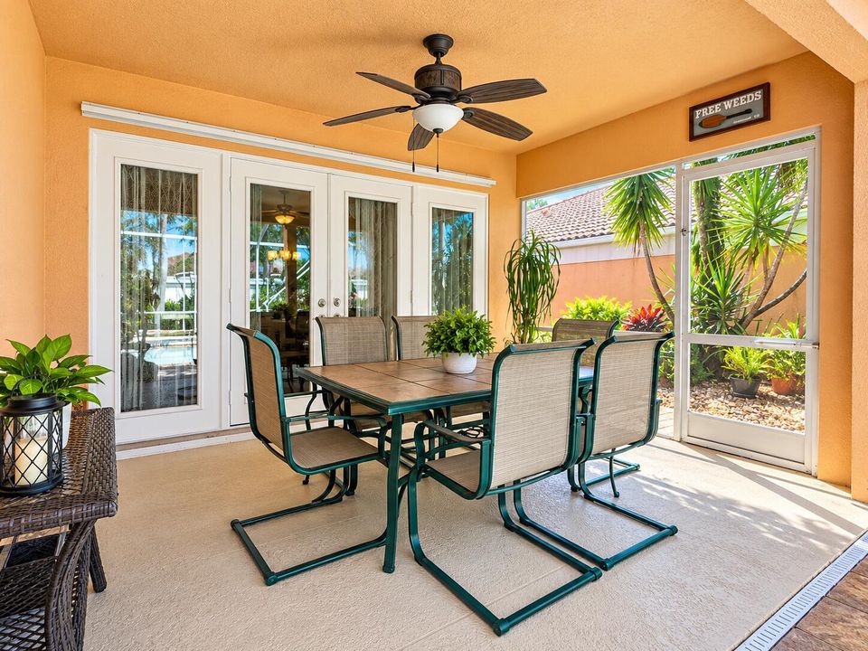 Bright Tropical Screened Porch Dining Ar