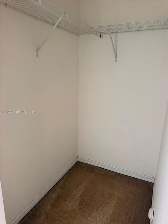Storage space featuring wall-to-wall wire shelving and carpeted flooring