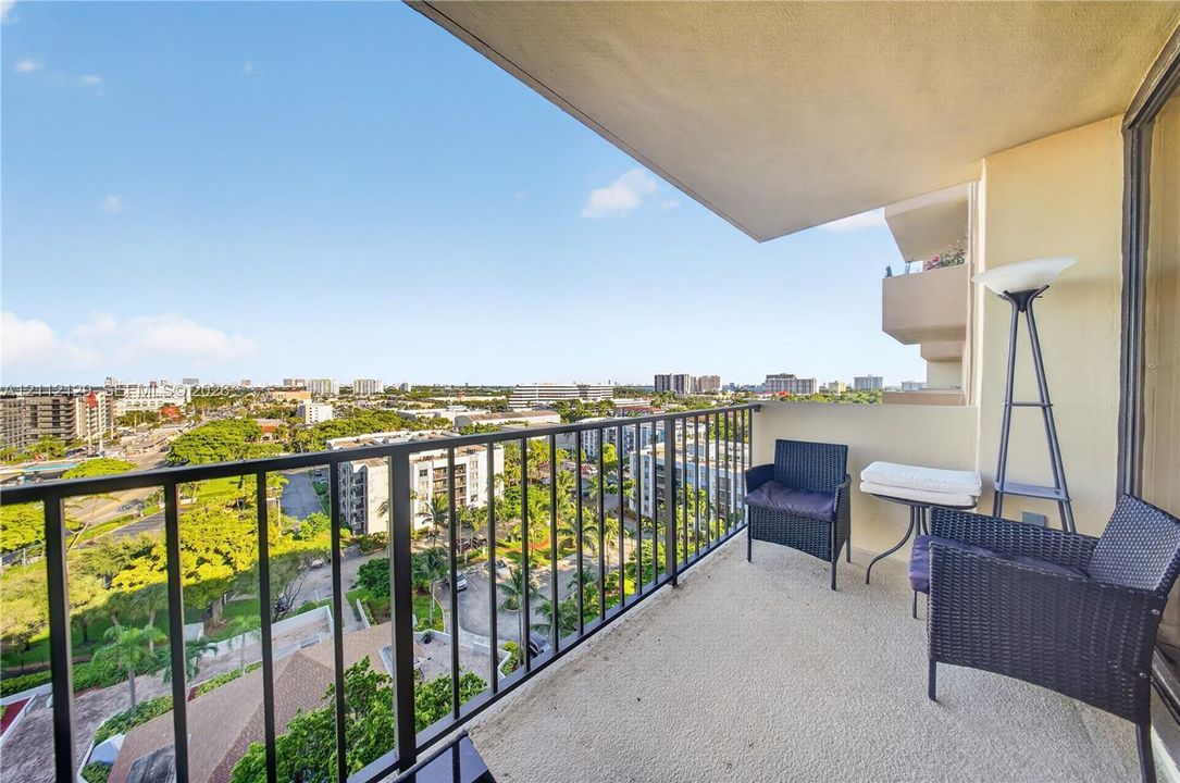 Covered private balcony featuring a black metal railing and concrete flooring